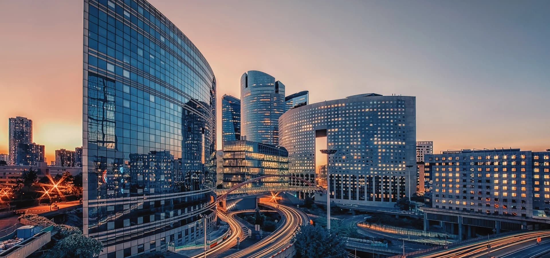 Modern office buildings across a city district at dusk